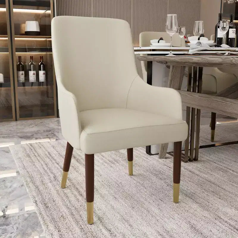 Sedia da pranzo in pelle con braccioli e gambe in legno con dettagli dorati